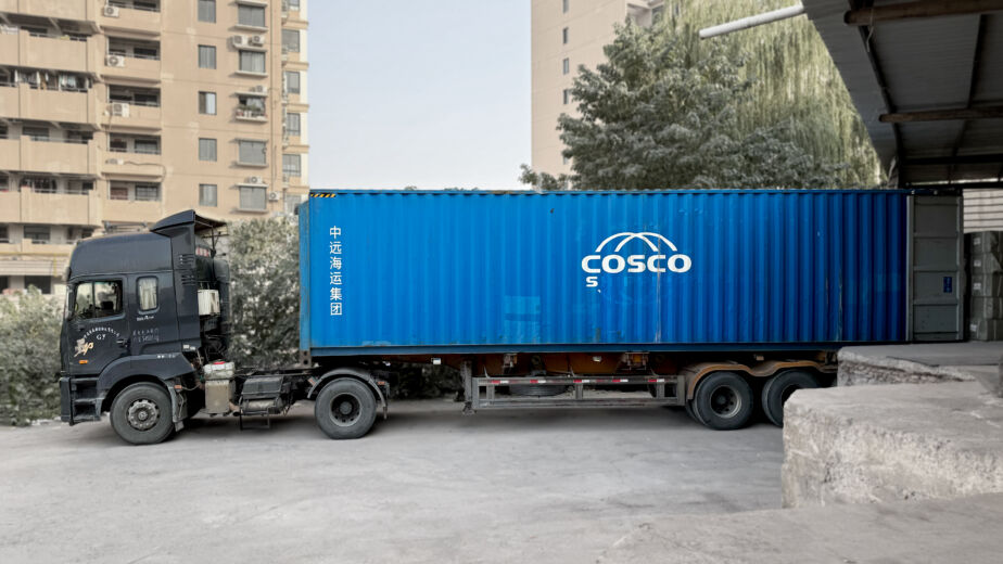 LCL vs FCL container consolidation — shipping container truck departing Yiwu